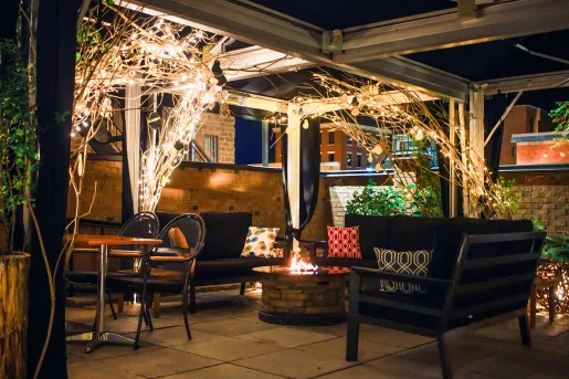 Outdoor patio and seating area with a fire pit in the center