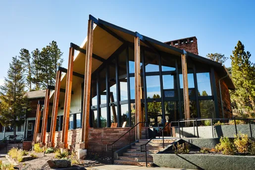 Exterior view of hotel building with large wooden pillars and large windows