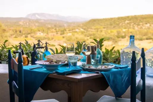 Outdoor dining table with blue cloths and wine glasses