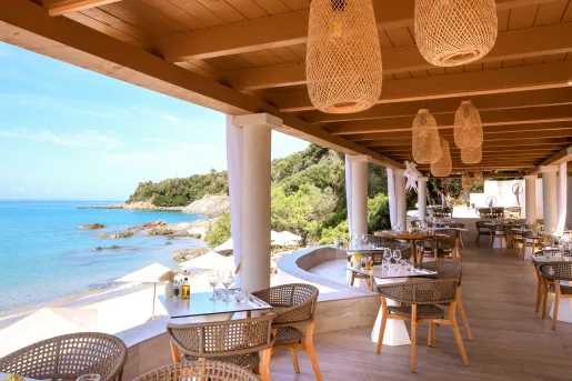 Outdoor patio with large wooden sunshade, with views of the ocean to the left