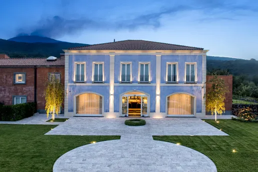 Exterior view of blue building with a large grass area in front