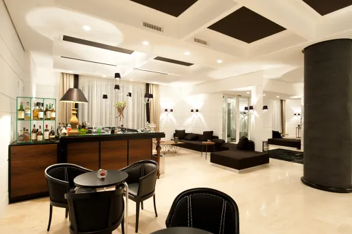 Bar and lounge with black chairs and tables, and a bar counter in the back