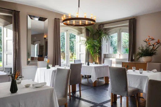 Indoor restaurant dining hall with gray chairs and white tables