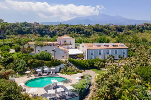 Outdoor, sky view of a hotel complex with an outdoor pool and large forest