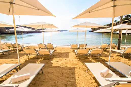 Beach with reclining chairs and umbrellas in front of the ocean