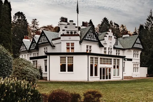 Exterior view of white and black building with a grass field in front