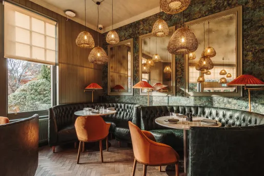 Dining area with green, circular sofas surrounding circular tables