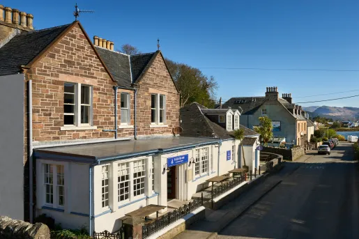 Exterior view of brick hotel building with a river in the distance