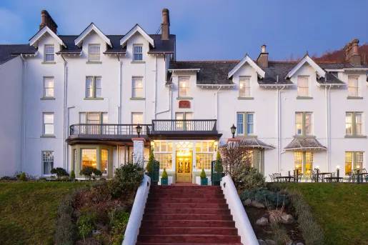 Exterior view of white hotel building with a red staircase in front