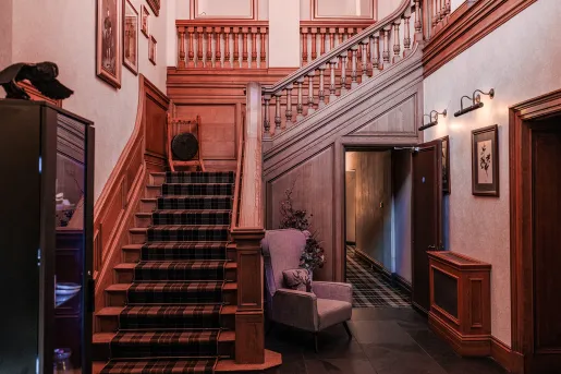 Building corridor with a large staircase to the left and a chair to the right