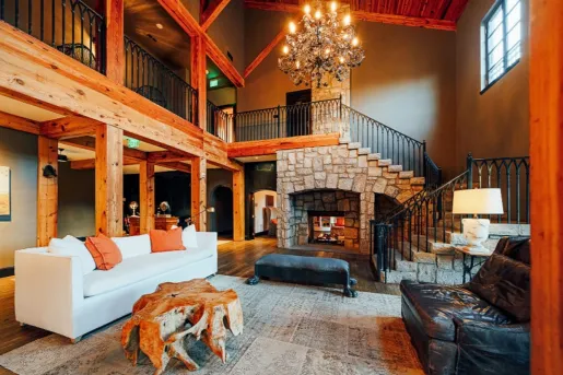 Wood cabin with large couch in front of fireplace
