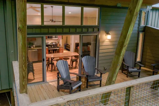 Outdoor patio with two chairs and a kitchen in the background