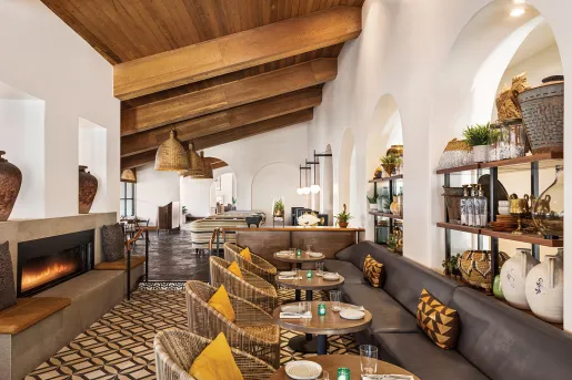 Indoor dining area with leather sofas and woven chairs, surrounding circular dining tables