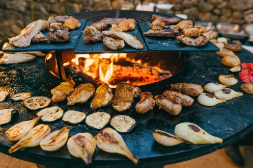Large grill with roasted vegetables and slices of meat