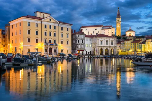 River leading up towards a town, illuminated by warm lights