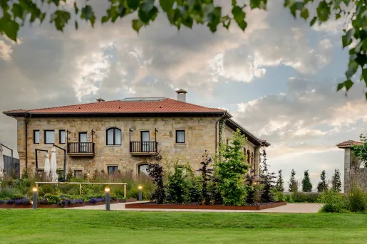 Exterior view of brick hotel building with grass field in front