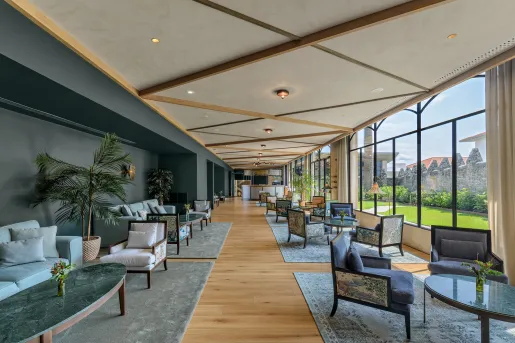 Long hallway with cushioned chairs and large windows to the right