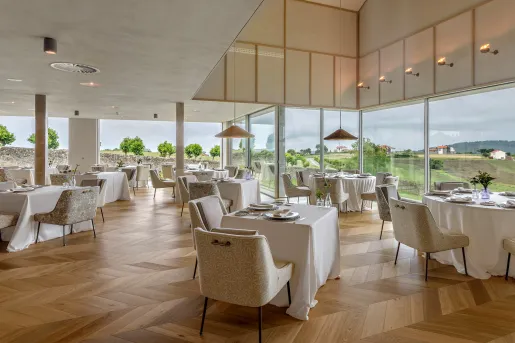 Dining hall with square white tables and large windows along the walls