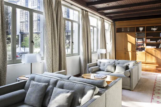 Seating area with gray, cushioned chairs and large windows