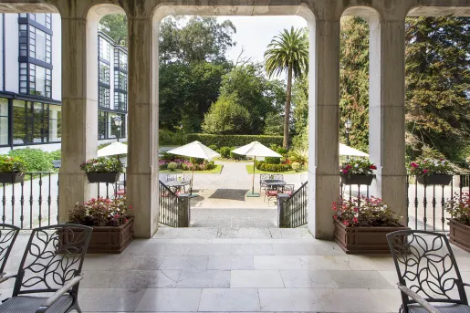 Outdoor courtyard with metal chairs and tables under umbrellas