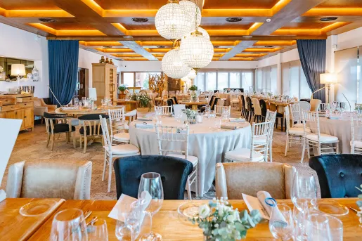 Indoor dining hall with circular dining tables and long, rectangular tables