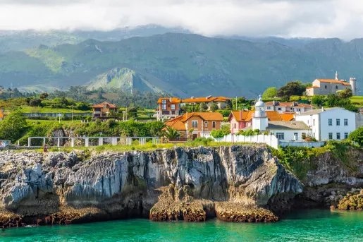 Row of houses by a cliff with the ocean in front