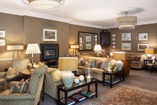 Seating area and lounge with cushioned sofas in front of a fireplace