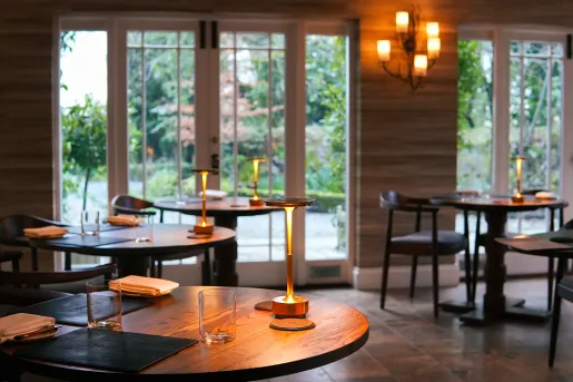 Dining area with circular tables and small lamps on each table