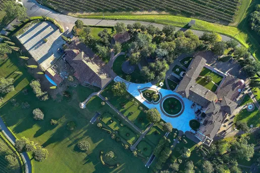 Sky view of a large building complex with large gardens and crop valleys