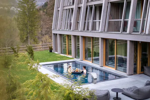 Outdoor pool with two people eating from a floating table