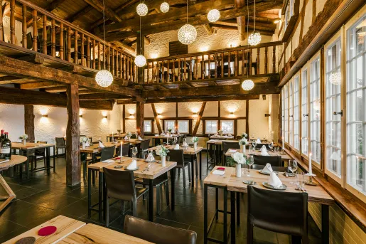 Two-story dining area with tables and black chairs