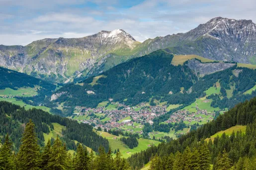 Sky view of a large valley with a town in the center, surrounded by tall mountains