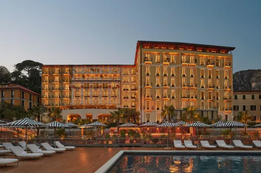 Exterior view of hotel building illuminated with an outdoor pool in front