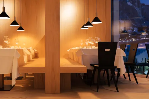 Restaurant dining area with two large tables and a wooden bench
