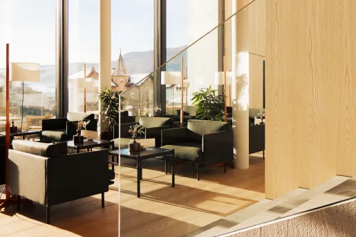 Hotel lounge with large windows and a glass staircase to the right