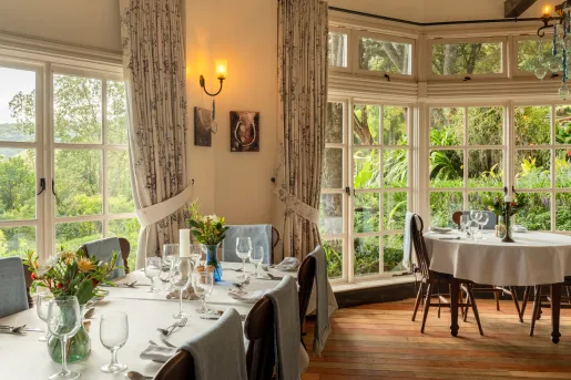 Restaurant dining hall with white dining tables and wooden chairs