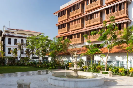 Exterior view of multi-level hotel building with a fountain in front
