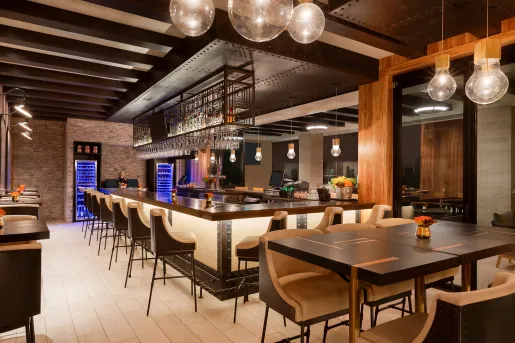 Indoor bar and lounge with black and brown cushioned stools
