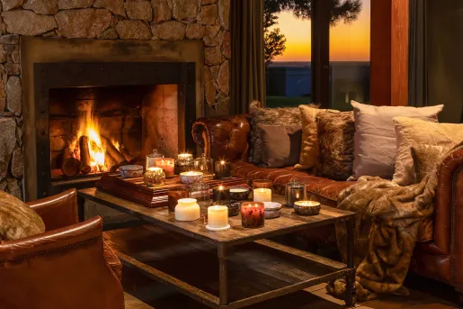 Cozy room with couches and a coffee table in front of a stone fireplace