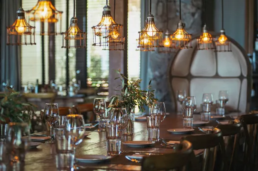 Dining hall with a large wooden dining table and glasses of water