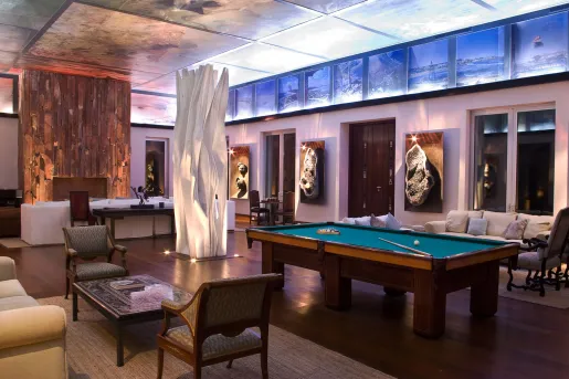 Lounge room with a billiards tables and couches along the room