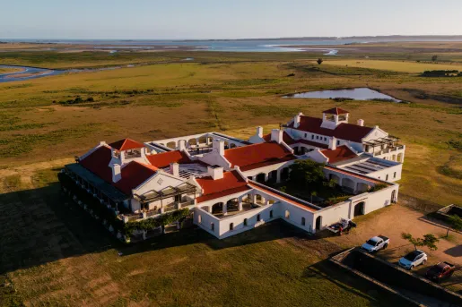 Sky view of white and red hotel building in the middle of a large valley