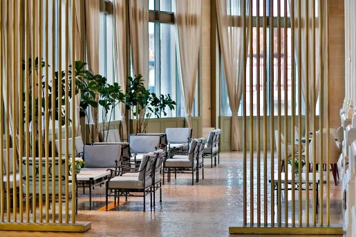 Lounge and seating area with beige couches and a wooden room separator