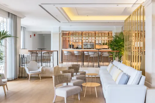 Hotel lounge area with cushioned sofas and a bar counter in the background