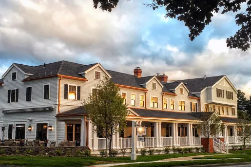 Exterior view of long, gray building with trimmed grass around sidewalks