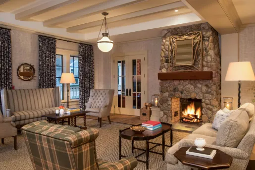 Lounge and seating area with cushioned chairs in front of a fireplace