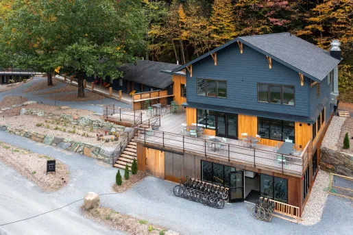 Gray and brown wooden building with an outdoor patio and bikes parked out front