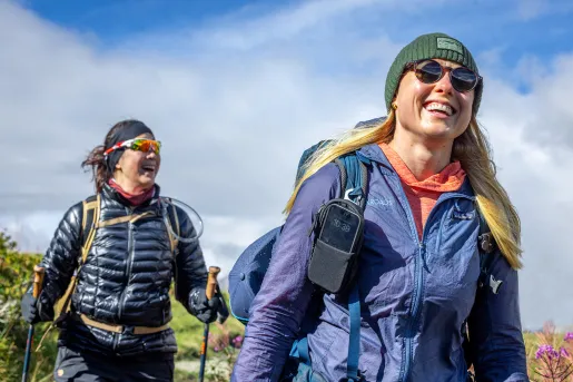 Two women smiling while hikings in an open field
