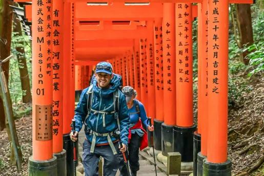 Man and woman smiling while walking along a Japanese shrine