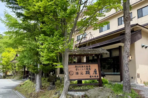 Exterior view of a beige, colored building with a Japanese sign in front